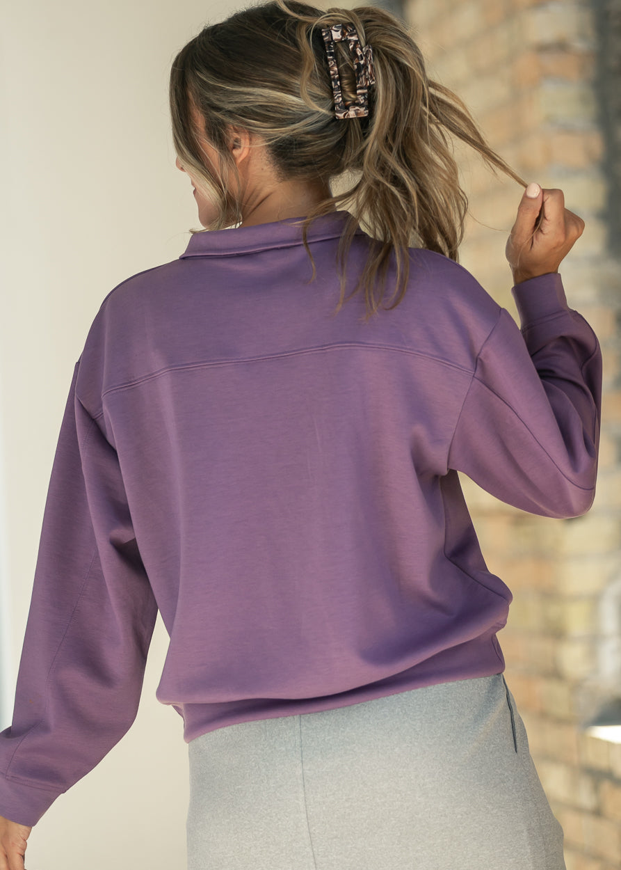 Back of dusty purple quarter-zip sweatshirt showing the yoke seam and funnel mock neck.