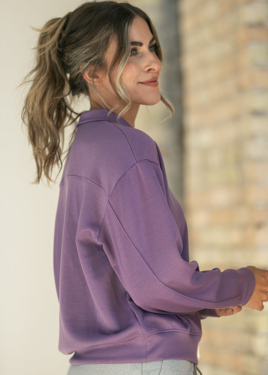 Side view of dusty purple quarter-zip mock neck sweatshirt with dropped shoulder seams.