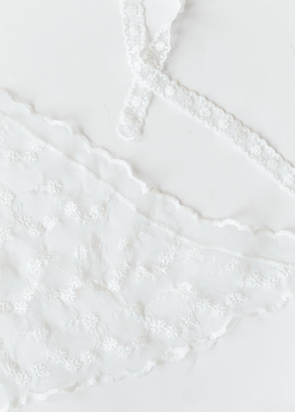 Ivory lace triangle scarf with floral embroidery, scalloped edges, and functional lace ties laid flat.