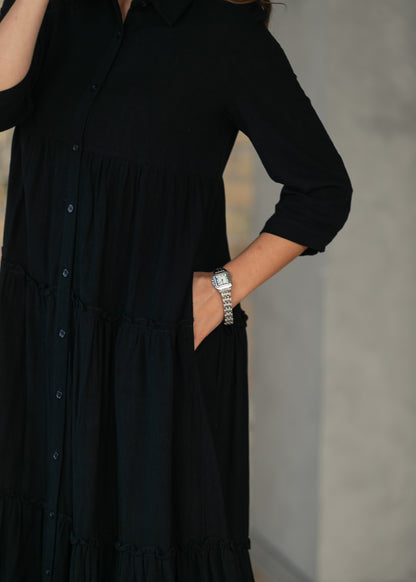 Close-up of black Elsie midi dress with hand in functional side pocket.