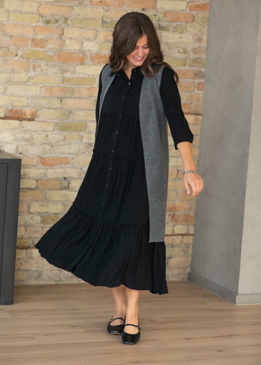 Black tiered midi dress in motion showing the flow of the A-line skirt.