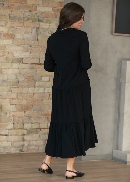 Back of black midi dress showing the tiered A-line skirt and half sleeves.