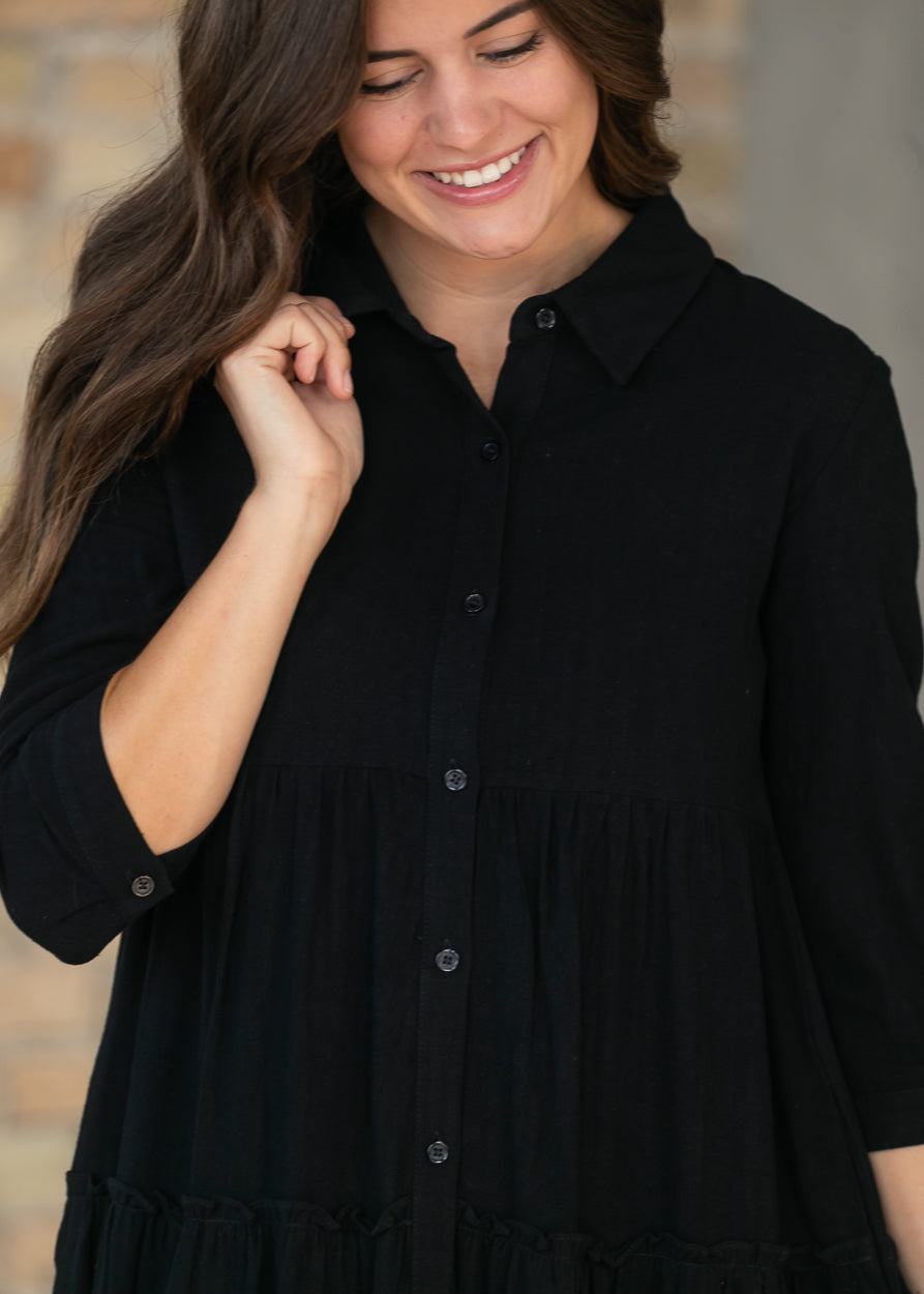 Close-up of black Elsie dress showing the V-neck and functional button front.