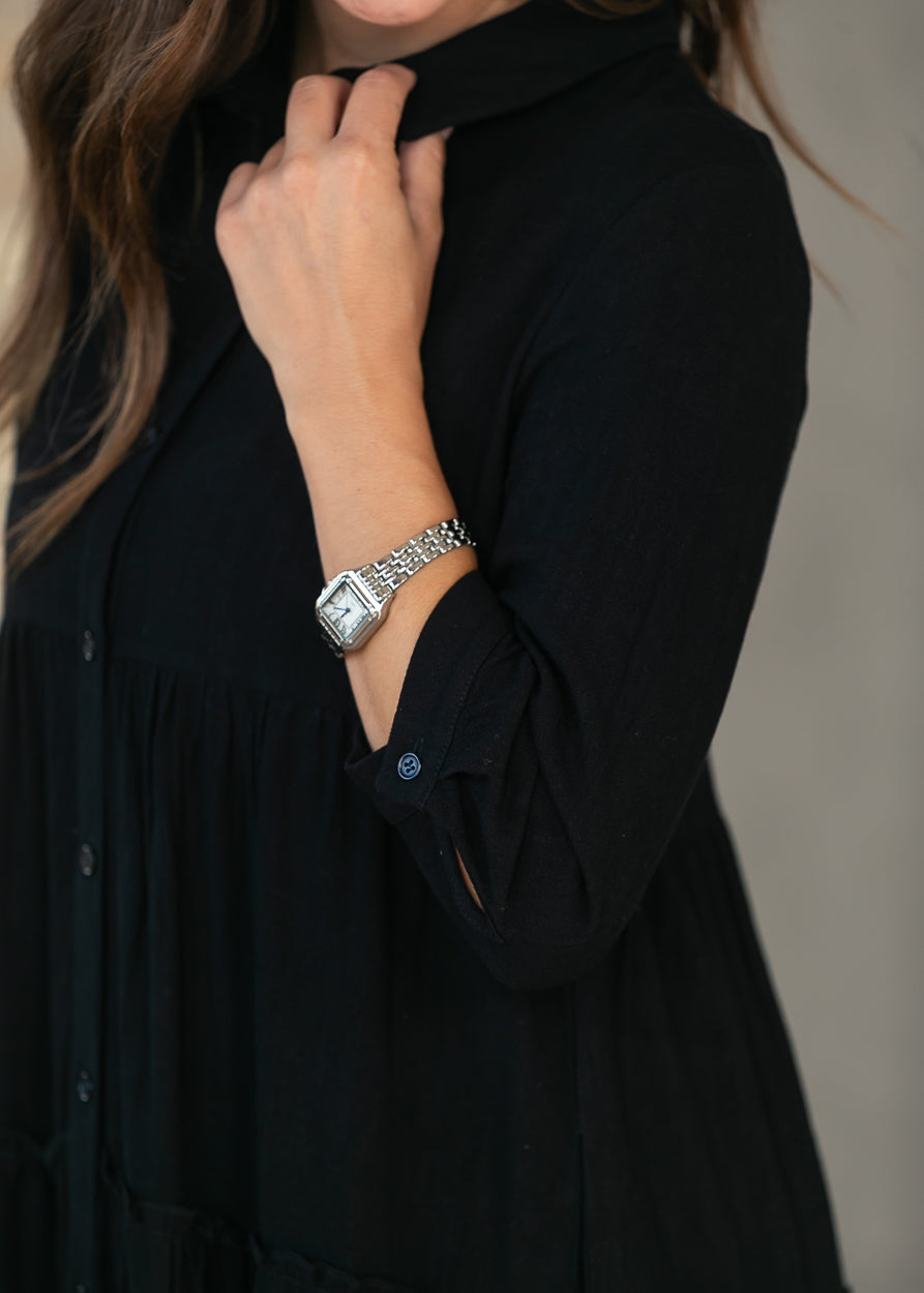 Close-up of black half sleeve dress showing the sleeve length and fabric drape.
