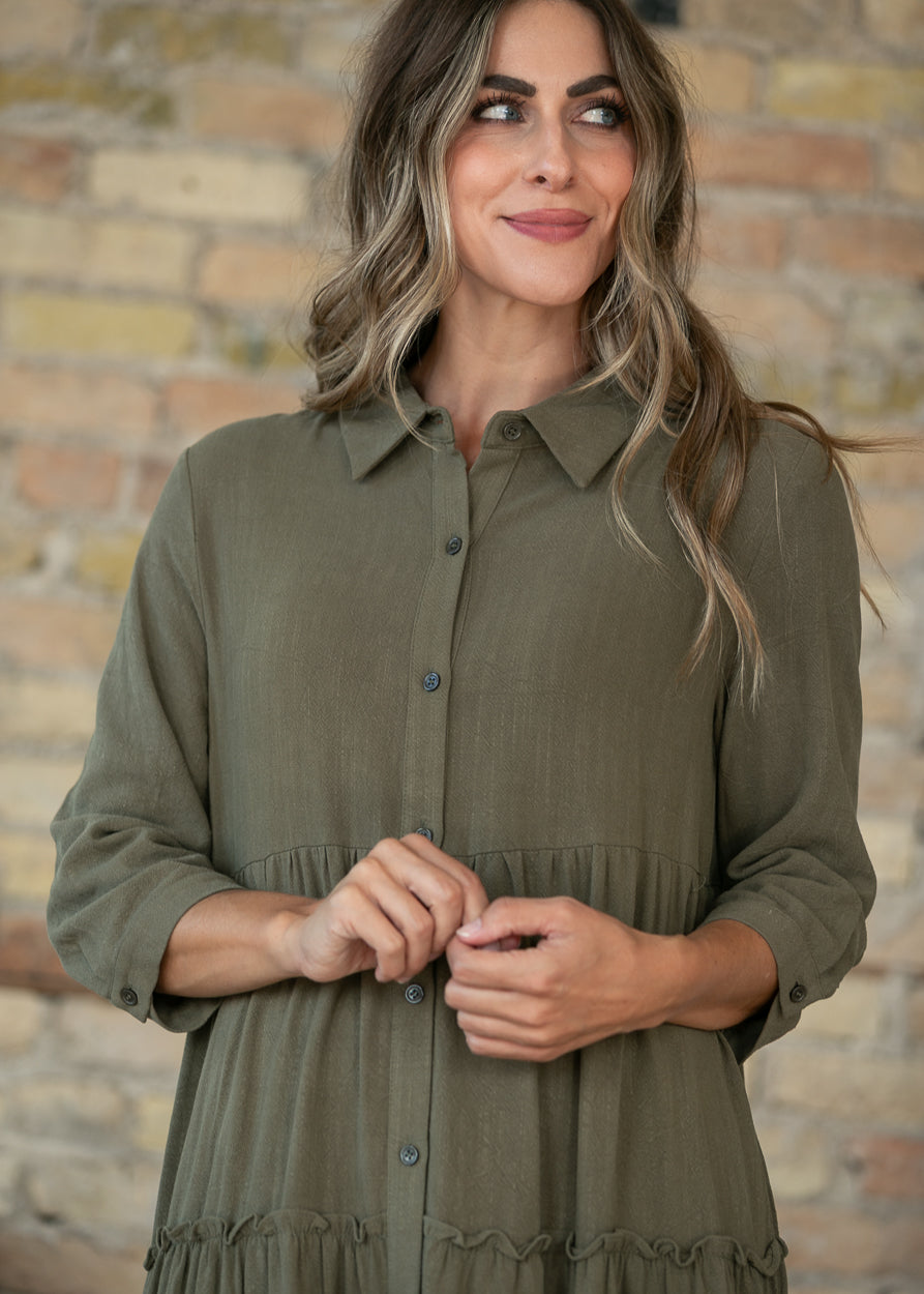Olive button front midi dress with half sleeves and V-neck, styled against a brick wall.