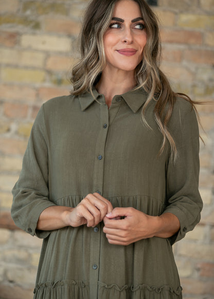 Olive button front midi dress with half sleeves and V-neck, styled against a brick wall.