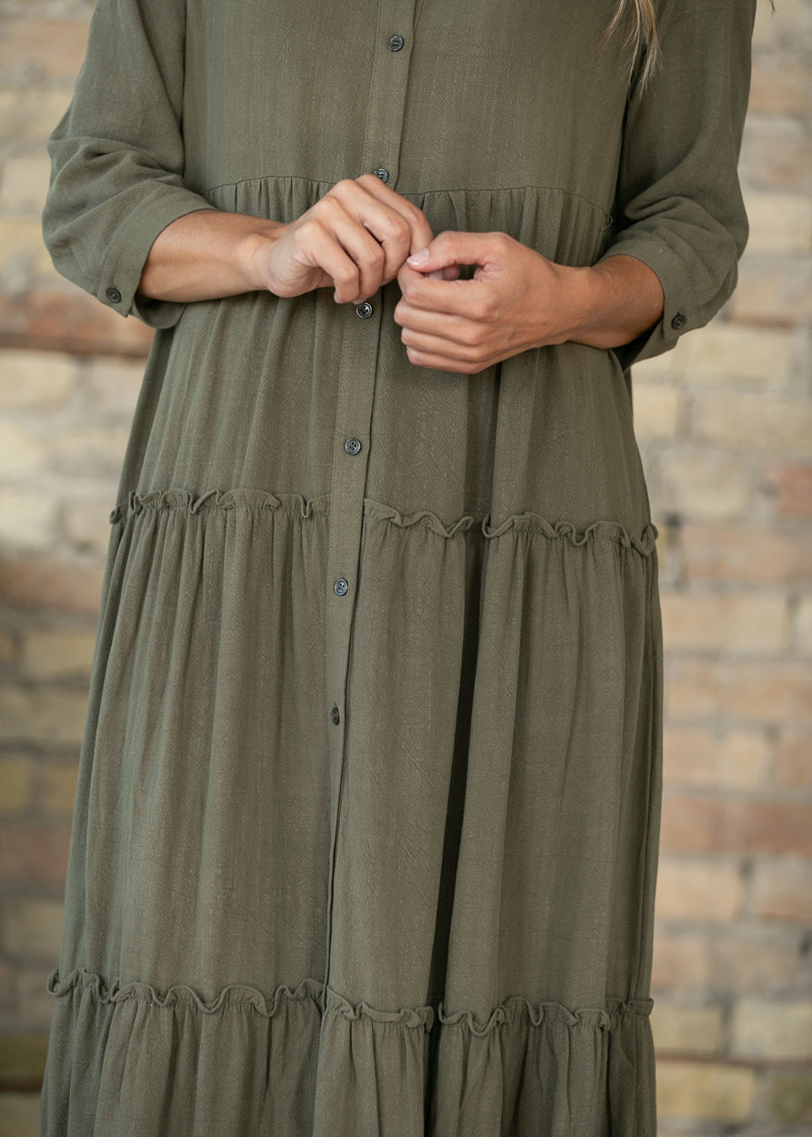 Close-up of olive Elsie dress showing the button front and tiered skirt construction.