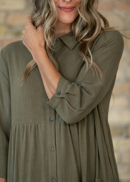 Close-up of olive midi dress showing the V-neck, half sleeves, and soft fabric drape.