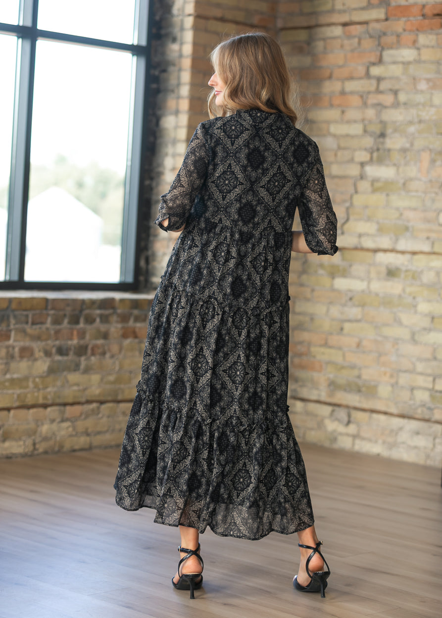 Back of black and cream paisley midi dress showing the half sleeves and tiered silhouette.