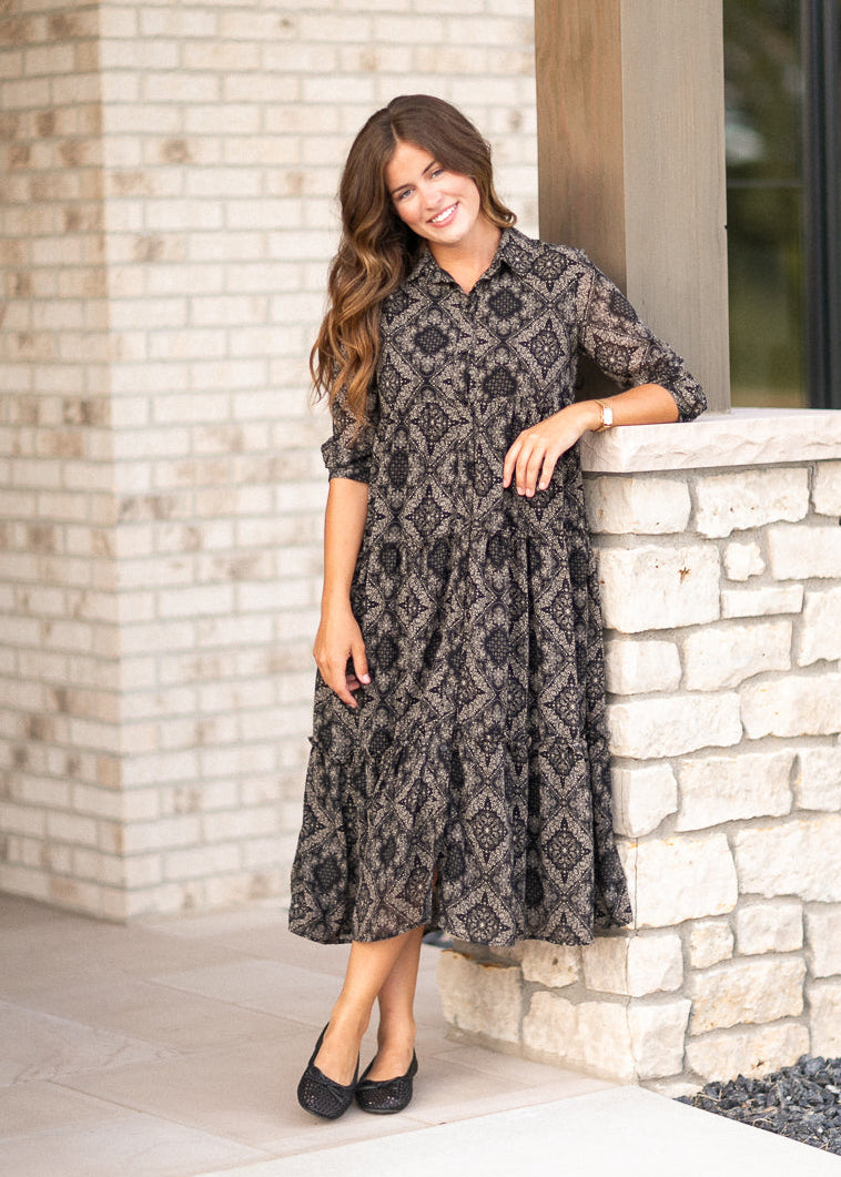 Elsie midi dress beside a stone wall showing the tiered calf-length skirt.