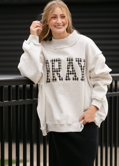 Front view of oatmeal sweatshirt with gingham Pray lettering, mockneck, and relaxed sleeves.