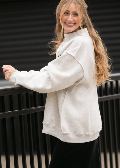  oatmeal heather mockneck sweatshirt showing oversized fit, dropped shoulders, and ribbed hem.