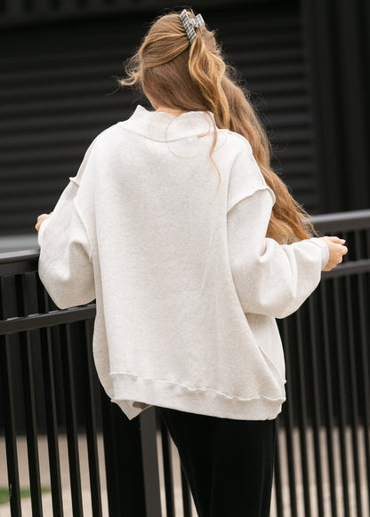 Back of oatmeal heather mockneck sweatshirt showing oversized fit, dropped shoulders, and ribbed hem.