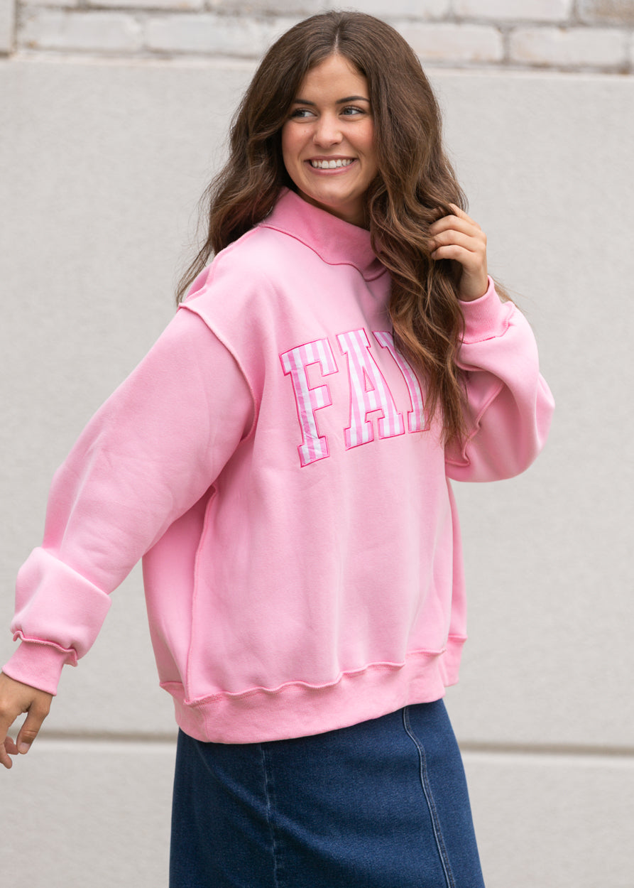 Side view of pink Faith sweatshirt showing dropped shoulders, relaxed sleeves, and ribbed trim.