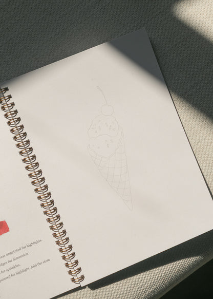 Americana watercolor workbook open to an ice cream cone sketch practice page.