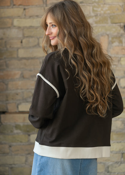 Back of espresso crewneck sweater showing drop shoulders and cream contrast hem and sleeve trim.
