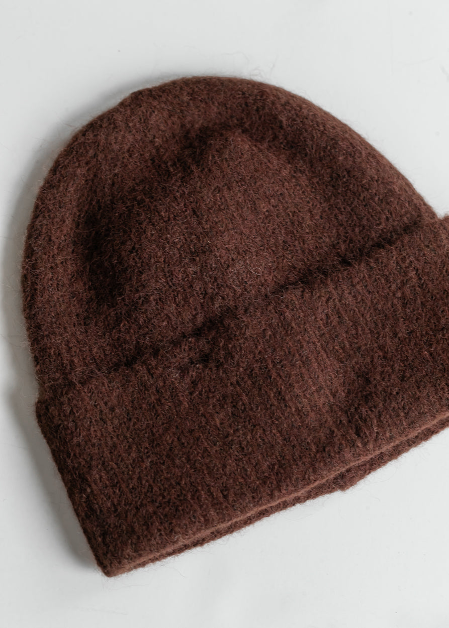 Close-up of brown wool-blend beanie showing soft fuzzy knit texture and warm brown color.