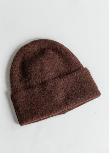 Brown soft knit beanie with a cozy fuzzy finish, styled with a cream ribbed long sleeve top.