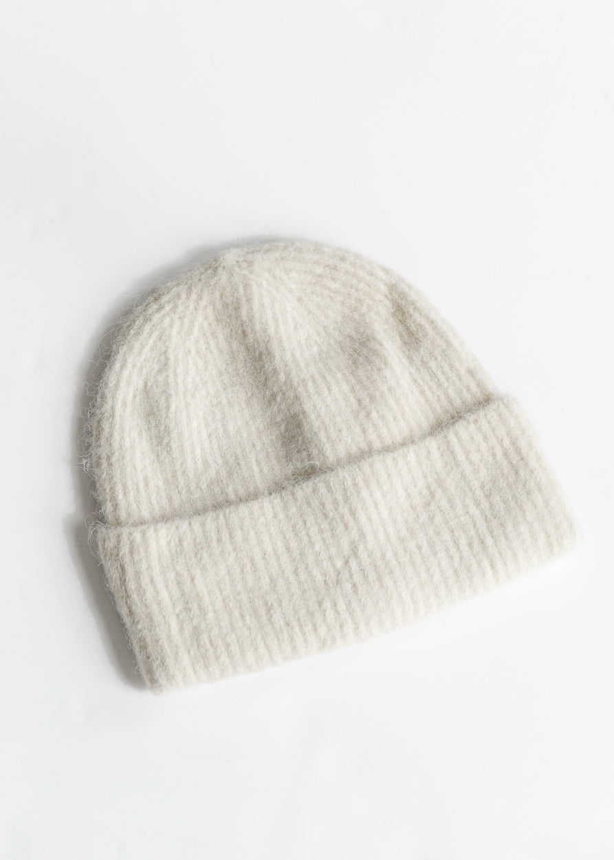 Ivory wool-blend beanie with ribbed texture and wide fold-over cuff on white background.