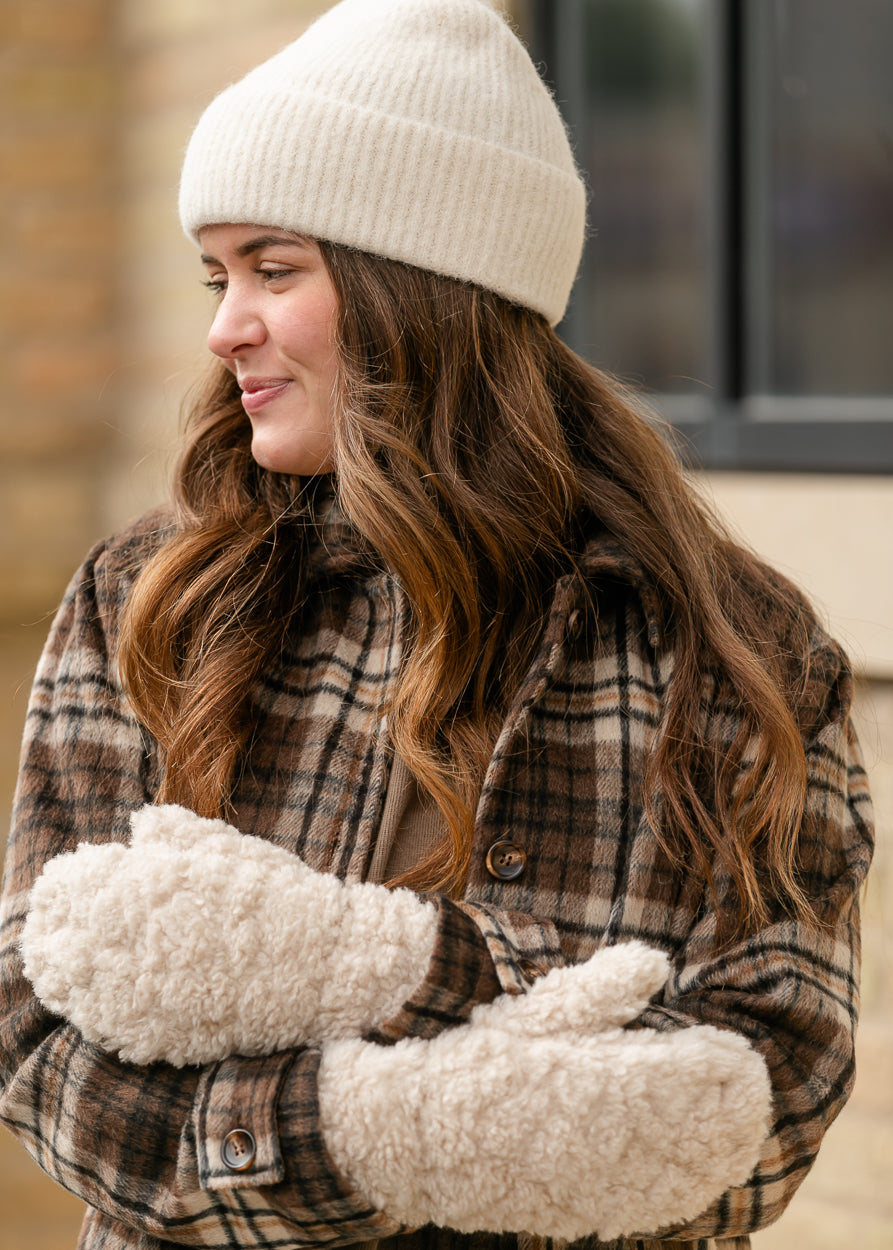 Soft ivory knit beanie styled with a plaid coat and cream fuzzy mittens.