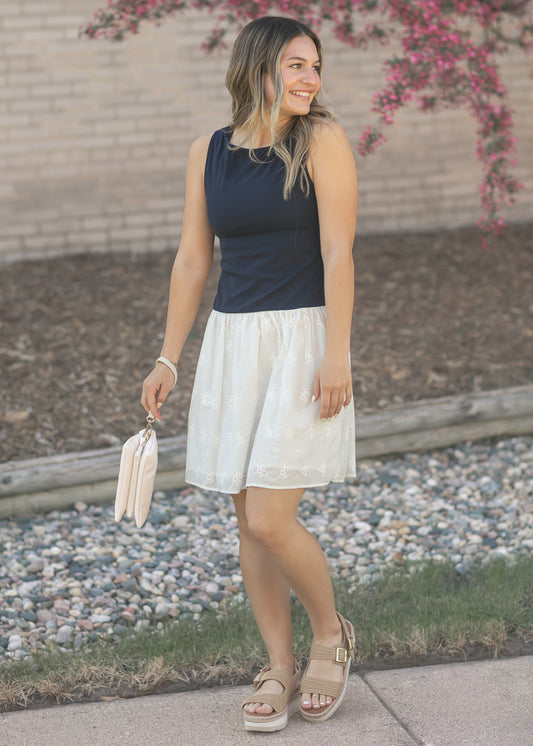 Navy fitted bodice dress with ivory eyelet midi skirt and neutral platform sandals