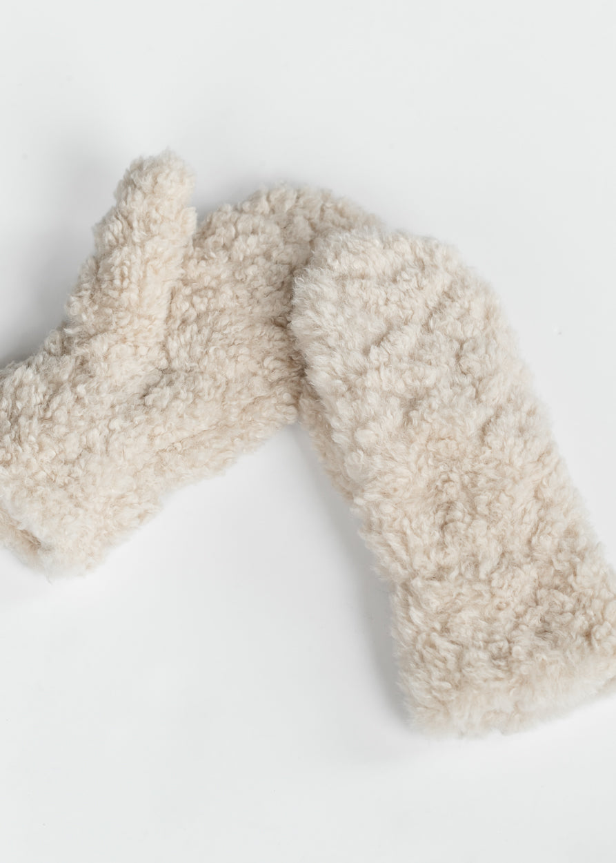 Beige faux shearling curly mittens with soft textured finish arranged on a white background.