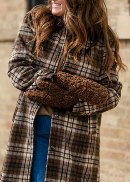 Brown curly mittens paired with a plaid coat for a cozy cold-weather look.