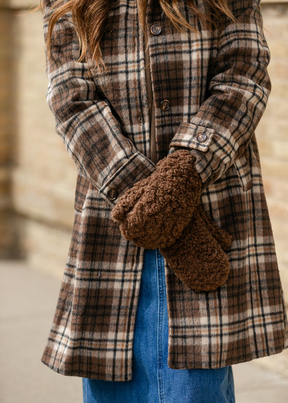 Close-up of brown faux shearling mittens with plush curly texture and winter coat styling.