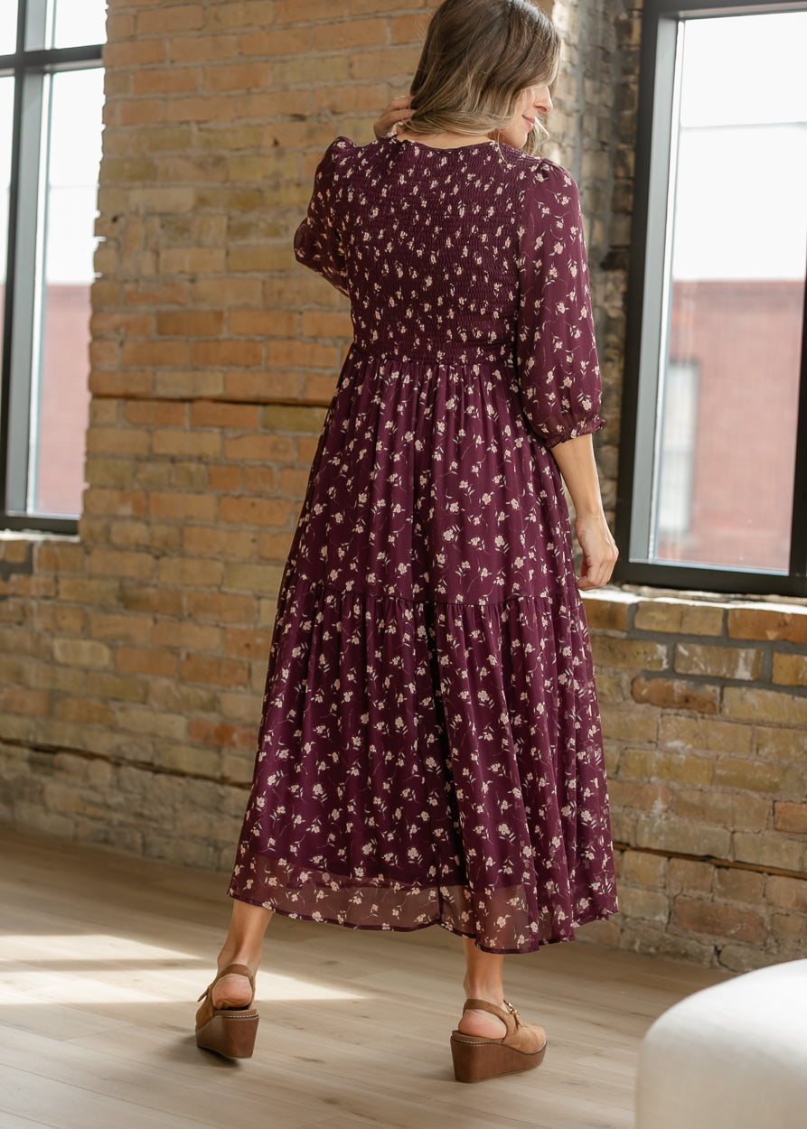Back of burgundy floral midi dress showing the stretchy smocked bodice and flowing skirt.