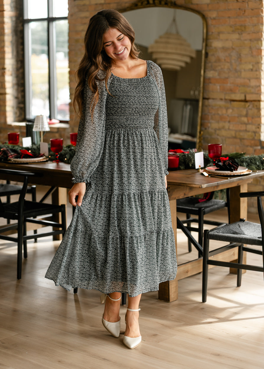 Hunter green floral smocked midi dress styled with white heels for a polished occasion look.