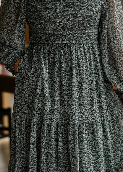 Close-up of hunter green floral midi dress showing the tiered skirt, side pocket, and petite ivory print.