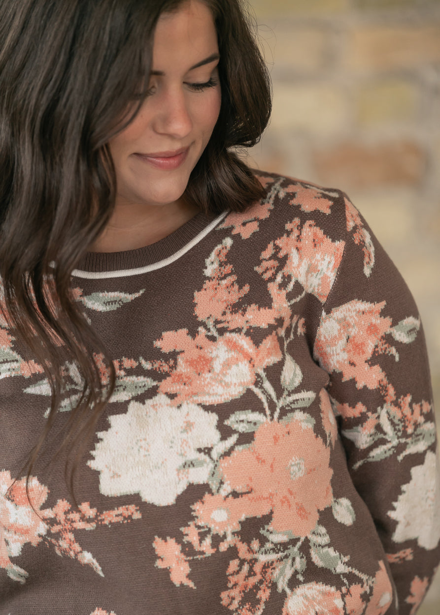 Brown floral jacquard knit crew neck sweater with peach and cream flowers and contrast neckline trim.
