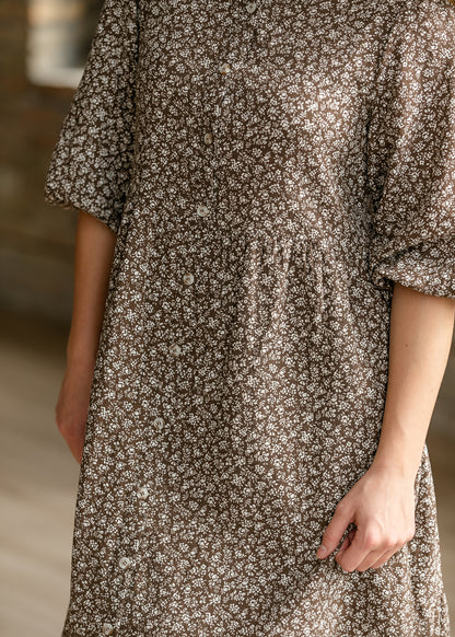 Close-up of brown and cream floral print with functional buttons and gathered waist.