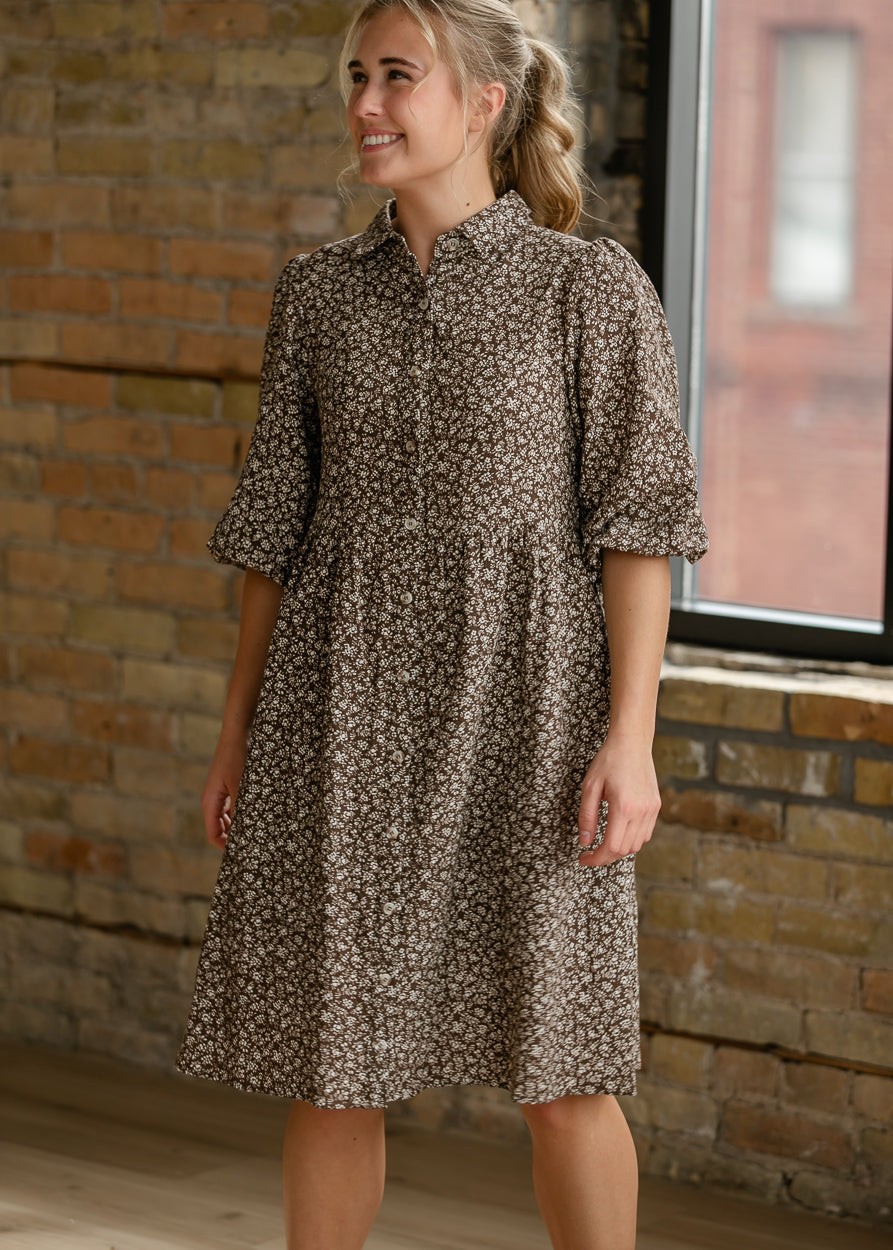 Brown floral dress with functional button front and elbow-length puff sleeves.