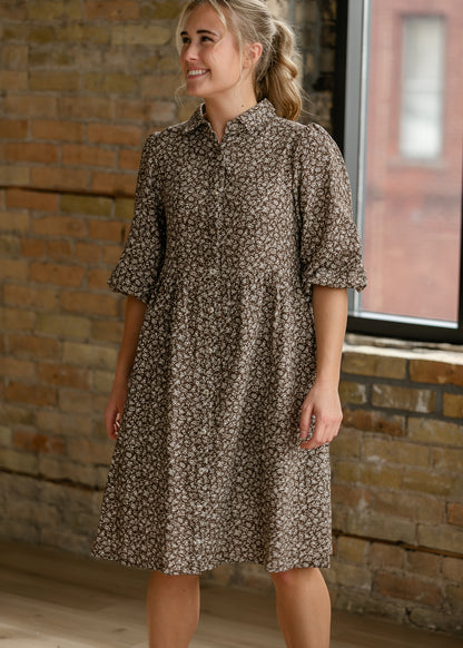 Brown floral dress with functional button front and elbow-length puff sleeves.