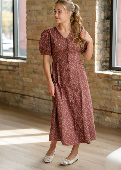 Brown floral button-front midi dress with short puff sleeves and softly gathered skirt.