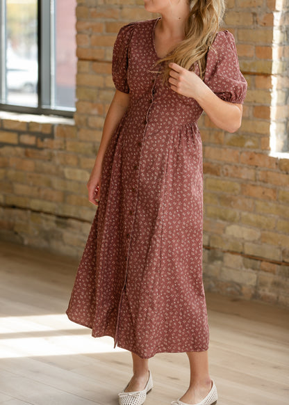Brown floral midi dress with puff sleeves, V-neckline, button front, and adjustable back waist tie.