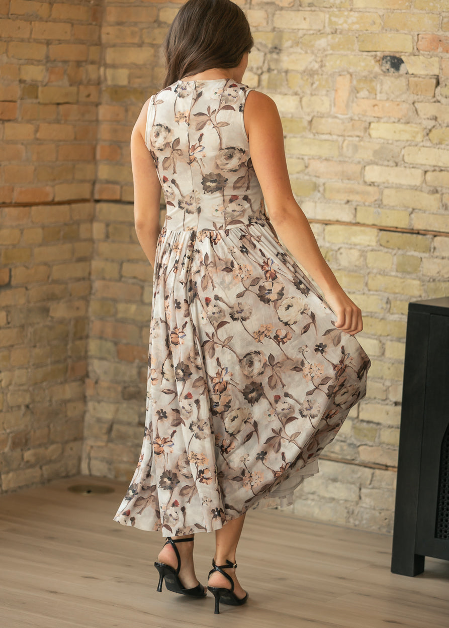 Back three-quarter view of neutral floral maxi dress with a full gathered skirt and sleeveless bodice.