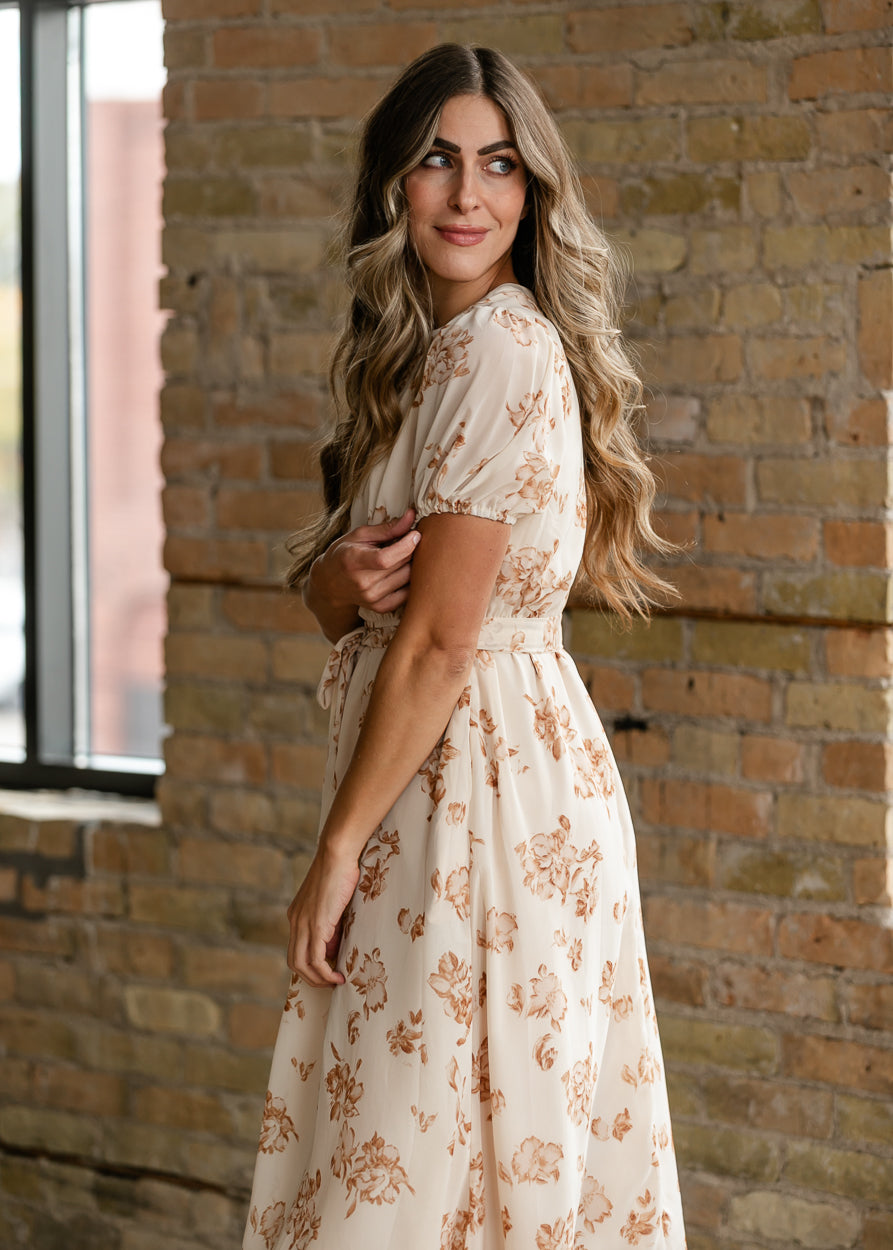 Side view of taupe floral midi dress showing short puff sleeve and defined waist.