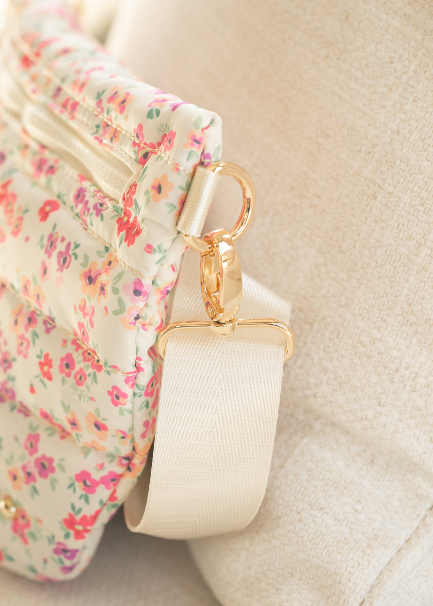 Close-up of floral quilted belt bag showing zippered compartment and quilted stitching details.