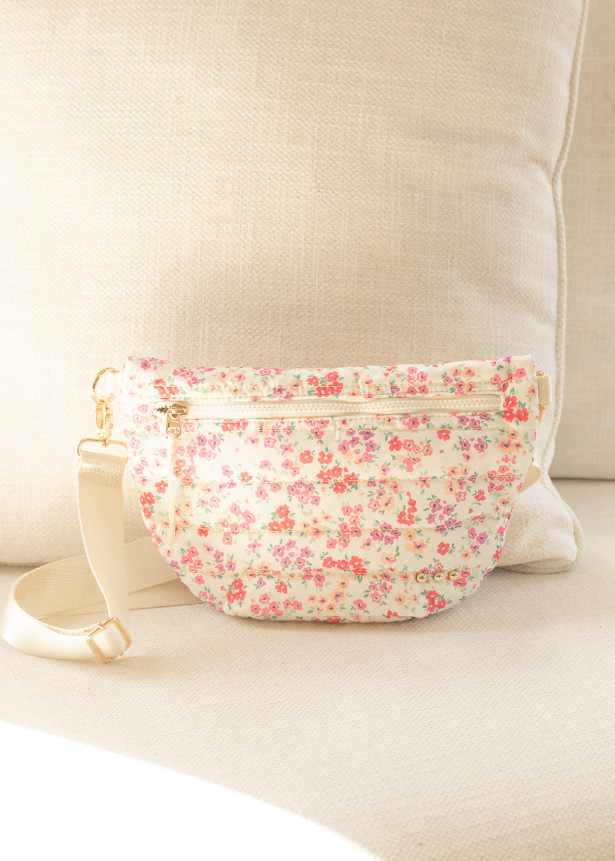 Floral quilted belt bag with quilted texture, floral print, and gold-tone zipper accents.