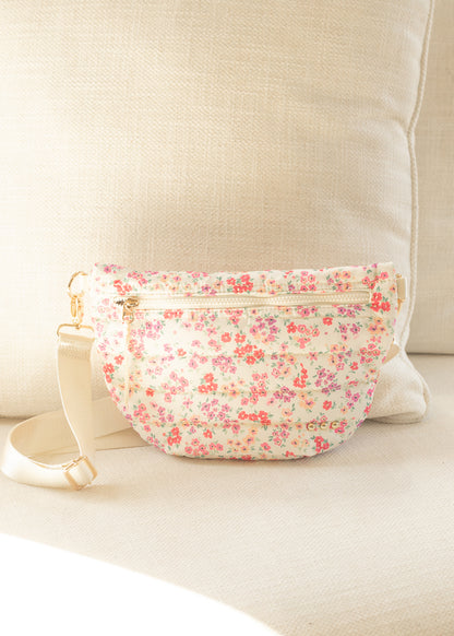 Floral quilted belt bag with quilted texture, floral print, and gold-tone zipper accents.