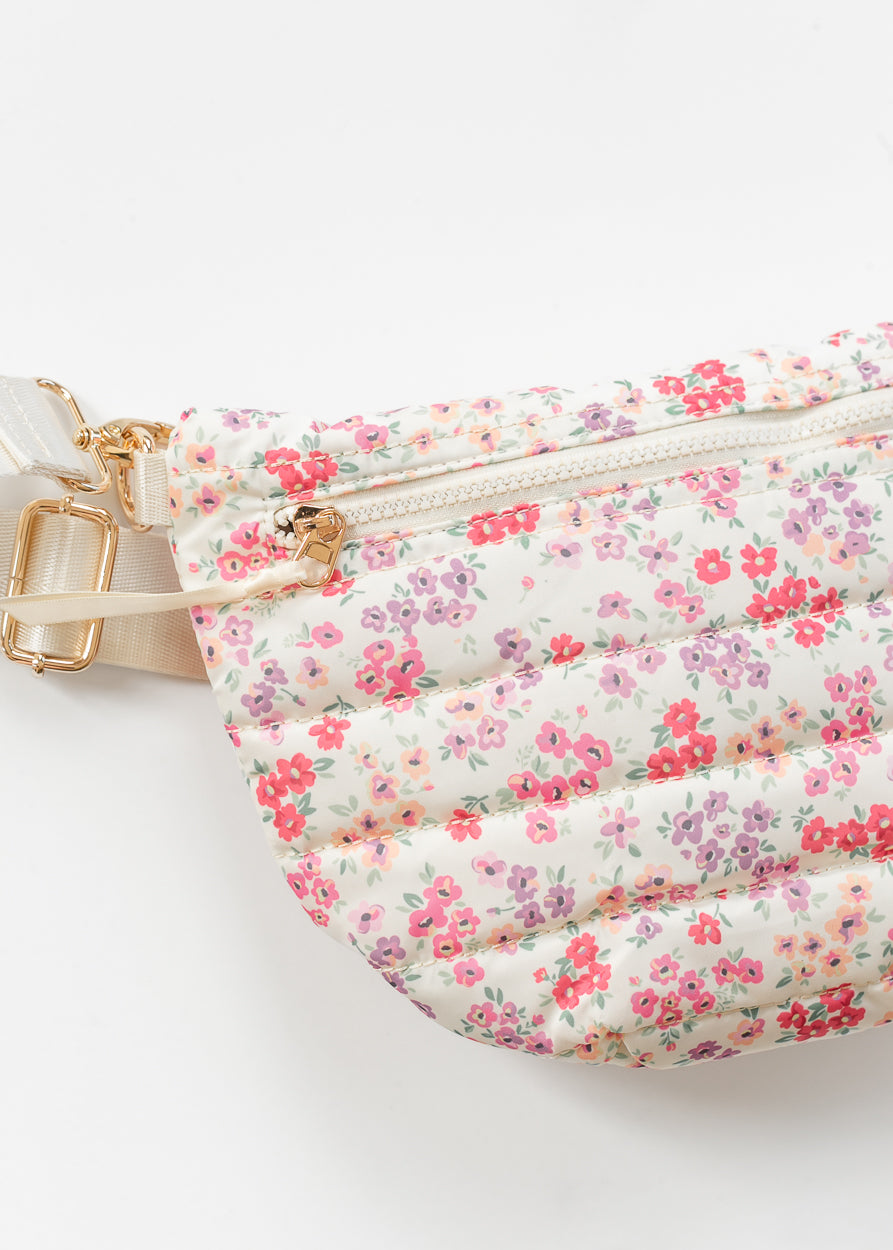 Floral quilted belt bag with front zip pocket and pink floral print on cream background.