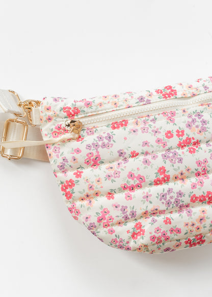 Floral quilted belt bag with front zip pocket and pink floral print on cream background.