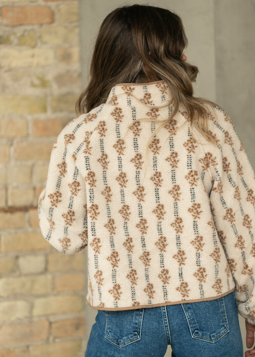 Back of cream floral fleece jacket showing the oversized hip-length fit and warm brown print.