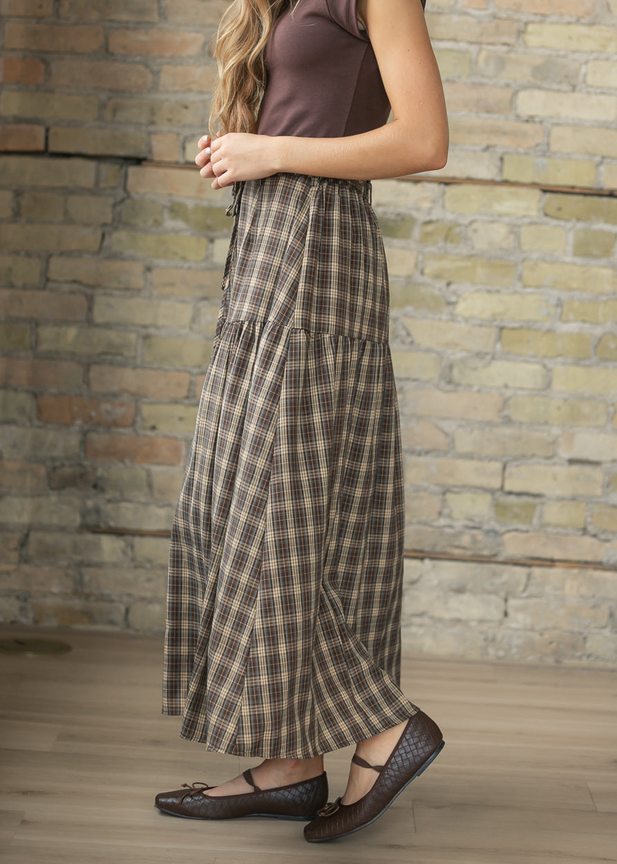 Side view of brown plaid maxi skirt showing the loose, flowy tiered silhouette.
