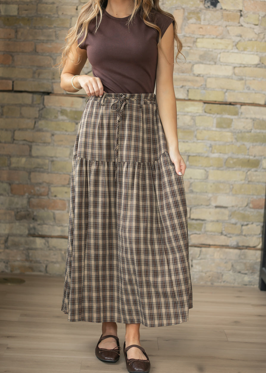 Brown plaid maxi skirt with drawstring waist, tiered silhouette, and ankle-length hem.