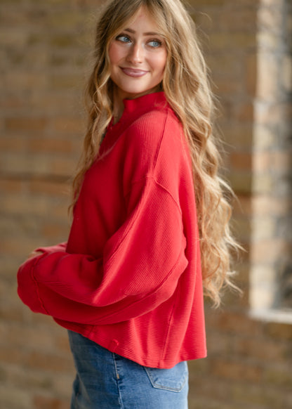 Free People Celeste quarter-zip top in bright red with oversized sleeves and relaxed everyday fit.