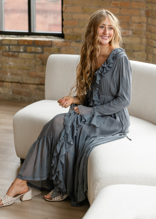 Free People ruffle midi dress styled seated, showing the textured fabric, long sleeves, and flowing skirt.