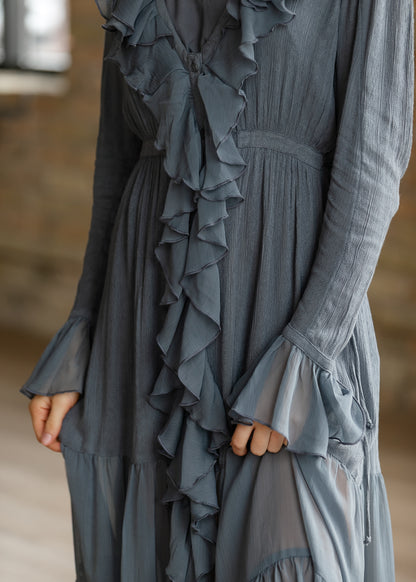 Full-length Free People Isla midi dress with ruffle neckline, long sleeves, tie waist, and airy tiered hem.